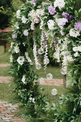 Fototapeta premium Lush round wedding arch with white and purple flowers 