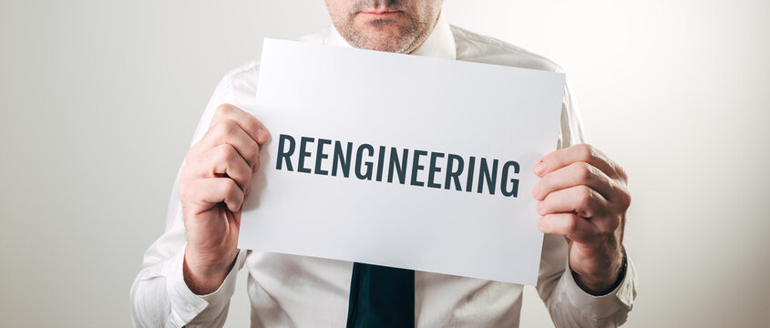 Businessman holding sign with REENGINEERING text