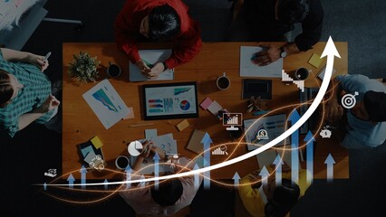 A dynamic team collaborates in a modern office setting, utilizing charts and digital data to strategize and enhance business performance and drive success. Raster