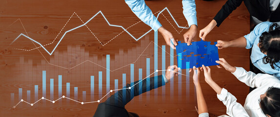 A diverse team collaborates over a table, analyzing data charts and fitting together puzzle pieces, representing teamwork and business strategy for growth. Scalp