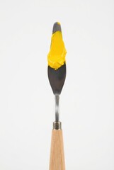 Paintbrush with yellow paint on a white background