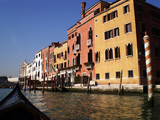 Drifting quietly along Venice s winding canals, a traditional gondola passes beneath arched bridges and alongside elegant historic buildings worn smooth by time and water. The gentle rhythm of the oar