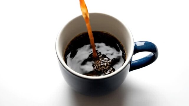 Pouring Fresh Hot Black Coffee into a Ceramic Mug on White Background