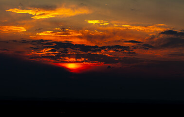 Obraz premium Soleil flamboyant sur l'horizon perçant les nuages dans la campagne du sud de la France