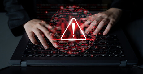 Two hands typing on a laptop keyboard with a digital warning icon. This image symbolizes cybersecurity risks, data breaches, and the critical need for online protection. Gantry