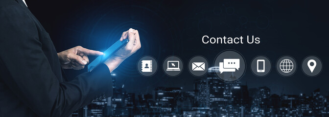 A businessman interacts with a tablet showcasing contact icons against a dynamic city skyline, symbolizing effective communication and engagement in the digital age. Gantry