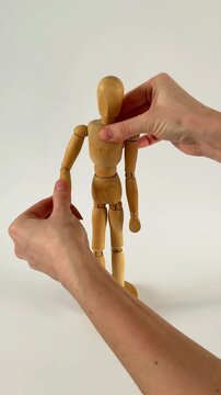 two hands holding hands. Wooden mannequin takes first steps, moving like a poseable figure. This articulated mannequin and wooden model captures realistic movement, perfect for artists 