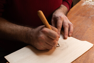The master carves a pattern on the board