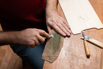 A craftsman polishes wood carving tools