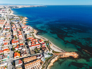 Aerial view of Torre de la Horadada townscape with Mediterranean Sea view during sunny day. Spanish resort, travel and touristic places concept. Costa Blanca, Alicante province, Spain 