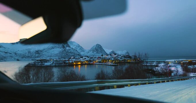 Hus&oslash;y im Winter zur blauen Stunde mit Blick in den Hafen, schneebedeckte H&auml;user und Boote im ruhigen Fjord, kalte Abendstimmung und klares arktisches Licht in Nordnorwegen