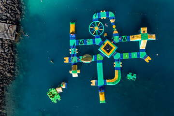 Aerial view of an inflatable water park in Gran Canaria with slides, balance beams, circular...