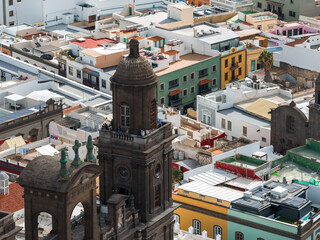 The Cathedral of Santa Ana bell tower rises over Vegueta in Las Palmas. Visitors stand on the...