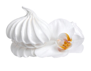 Swirled meringue sits next to a delicate white orchid blossom against a black background