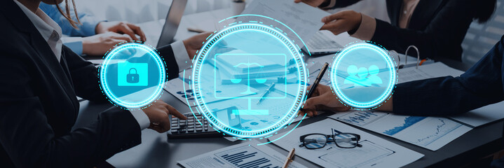 A group of professionals engages in a business meeting in a modern office, using technology icons to symbolize key themes like security, law, and health. Trope