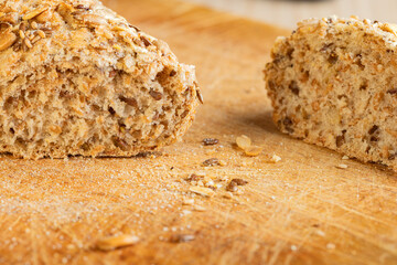 Rustic multigrain bread loaf sliced on wooden cutting board.