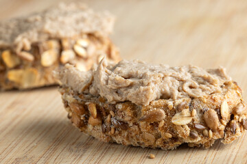 Rustic multigrain bread slice topped with fish spread.