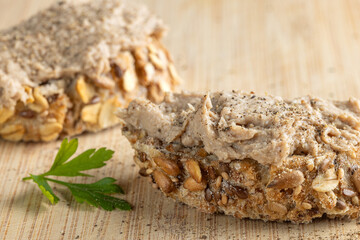 Rustic multigrain bread slice topped with fish spread.