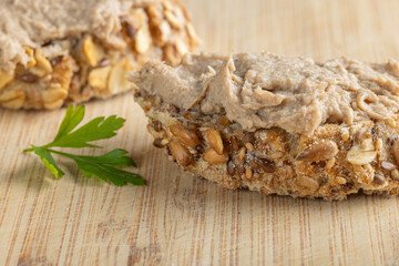 Rustic multigrain bread slice topped with fish spread.