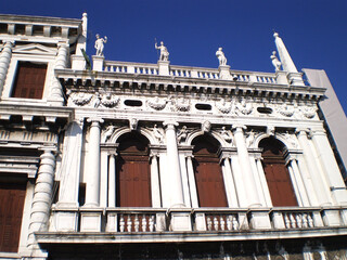 View of a historic building in Venice, Italy, showcasing classic Venetian architecture along the canals under a clear blue sky. Timeless urban scenery reflecting the city s rich cultural heritage