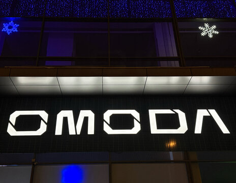 Facade of Omoda car store at night LED backlight. Omoda is an automobile manufacturer. Chinese Motor Corporation. Omoda Cars in the showroom with LED backlight. 