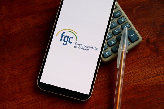 Salvador, Brazil - January 18, 2026: Fundo Garantidor de Creditos (FGC) logo on a smartphone screen. Brazilian bank deposit insurance and financial protection concept.