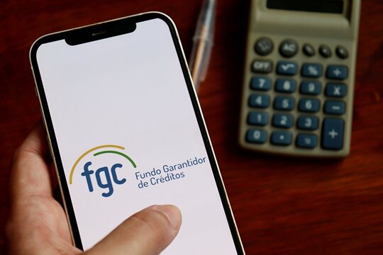 Fundo Garantidor de Creditos (FGC) logo on a smartphone screen. Brazilian bank deposit insurance and financial protection concept.