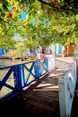Boardwalks and shops surrounding a lagoon and estuary behind Amber Cove in the Dominican Republic featuring lush greenery and egrets.
