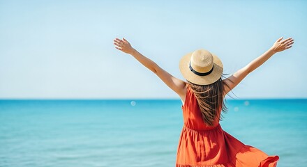 Woman in a red dress and straw hat stands by the ocean, arms outstretched, embracing the sun and sea, embodying joy and renewal during a vacation experience