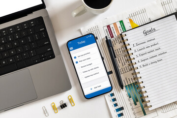 Business goals checklist app on office desk