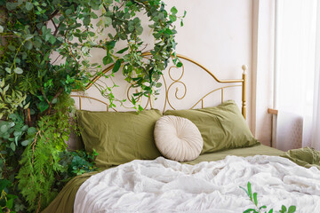 Cozy bedroom adorned with lush greenery and natural spring decor for tranquil atmosphere. Gold forged headboard, bed with soft green bedding. Lush plants creating peaceful relax elements and comfort.