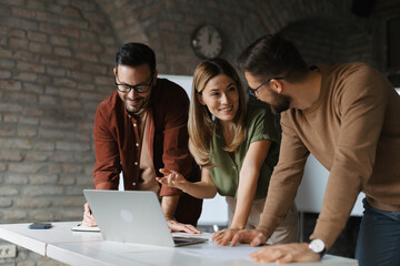 Diverse group of young professionals collaborating on a project in a modern startup office