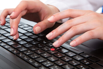 Close up of female hands typing on computer keyboard while working in office environment
