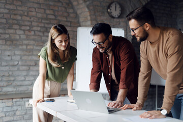 Diverse group of young professionals collaborating on a project in a modern startup office