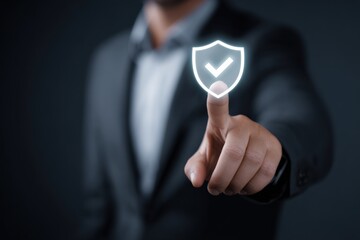 Young adult male in suit pointing at digital shield icon for cybersecurity