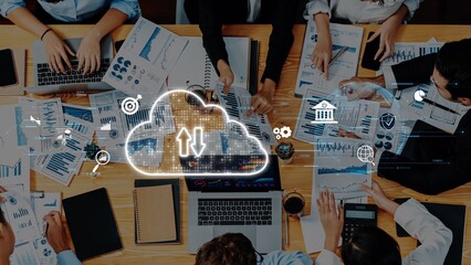 A dynamic business meeting featuring professionals engaged in data analysis and cloud technology, emphasizing teamwork and innovation in a modern workspace environment. Raster
