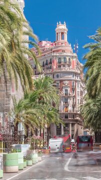 Timelapse of Banco de Valencia headquarters, historic landmark in Valencia, Spain. Stunning architecture with palm-lined street and busy traffic under a bright blue sky. Urban financial district scene