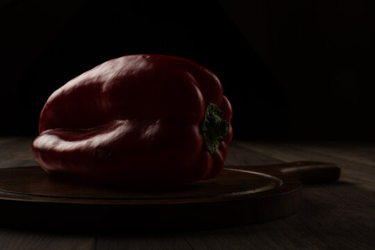 piment&oacute;n o pimiento rojo sobre una tabla, en clave baja