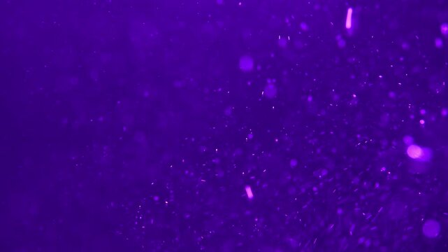 Deep purple abstract background with floating dust particles and soft bokeh lights resembling underwater bubbles or cosmic space dust
