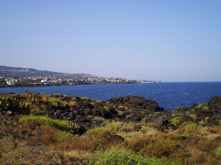 Catania embankment overlooking the beautiful blue sea in Sicily, Italy, featuring a scenic coastal promenade with views of the Ionian Sea. Picturesque Mediterranean landscape highlighting the seaside