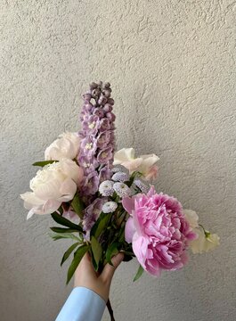 Woman's hand is holding bouquet of fresh flowers