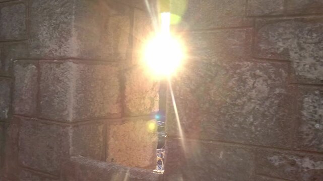 Panning in a fortress tower with sun through an arrow slit and view of Kotor and its bay, Montenegro
