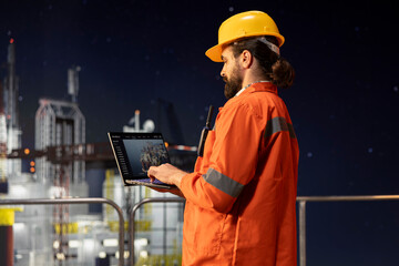 Drilling rig technician analyzing derrick performance on laptop dashboard screen. Offshore platform worker monitoring oil extraction rates and system pressure using notebook software