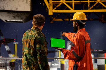 Green screen tablet with soldiers performing escort duty on a maritime vessel near offshore...