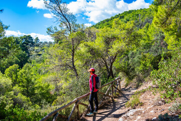 Female hiker on mountain path looking at stunning view of the Adriatic Sea in Gargano National Park, Italy, Apulia, Italy
