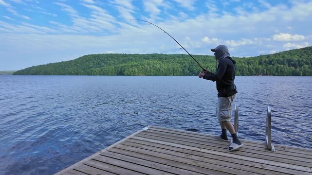 Man using finesse fishing angling style technique with light tackle rod, line, and lure with bobber. Angler setting the hook or hooking the fish during summer vacation fishing.