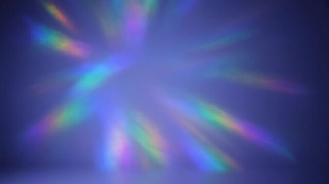 Abstract shimmering rainbow light beams refracting and moving against a dark blue background with dreamy soft focus.