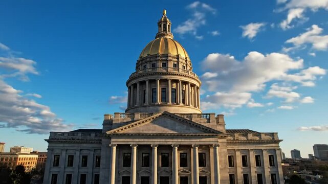 Drone Shot Ascending to Reveal the Impressive Gold Domed Government Building Against a Clear Blue Sky