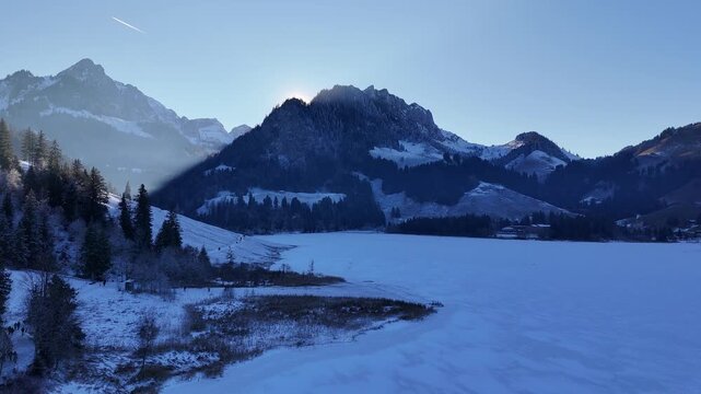 Aerial drone footage of frozen Schwarzsee lake in winter, Swiss Prealps, Fribourg, Switzerland