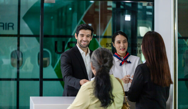 Asian senior passenger is showing her boarding pass to the airline ground crew at departure gate into the airplane for final inspection before boarding into plane
